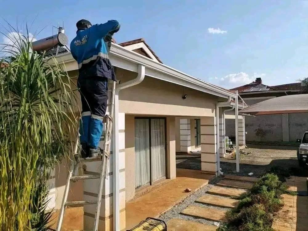 Installer fitting gutters on a residential roofline