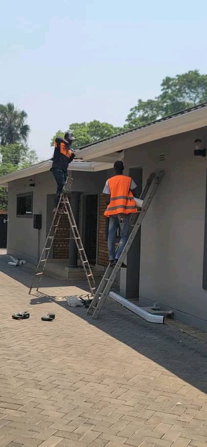 Two-person crew installing a full perimeter gutter system